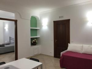 Habitación con cama, mesa y puerta en Villa Andalù Appartamenti, en San Giovanni Rotondo