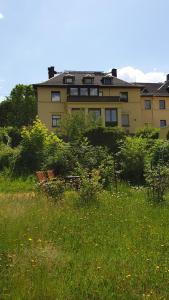 um edifício ao fundo com um campo de relva em Ferienwohnung Talblick em Annaberg-Buchholz