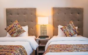 una habitación de hotel con 2 camas y una lámpara en una mesa en Offto Resort Hunza, en Hunza
