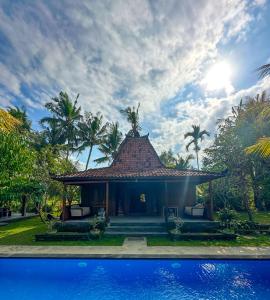 a resort with a pool in front of a house at Nunu Bali Eco Friendly Retreat in Canggu