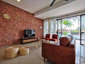 a living room with a couch and a brick wall at Port Dickson Pool Villa - Ruma66 (Up to 22 Pax) in Port Dickson