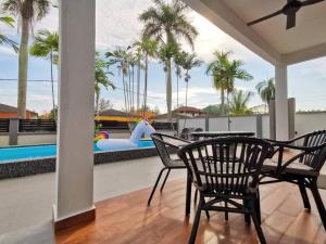 a patio with a table and chairs and a pool at Port Dickson Pool Villa - Ruma66 (Up to 22 Pax) in Port Dickson