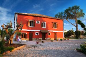una casa roja con un patio frente a ella en B&B La Chora Di Paestum, en Paestum