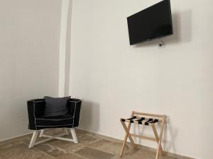 a room with a chair and a tv on a wall at Al Duomo Rooms in Corato
