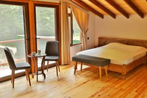 a bedroom with a bed and two chairs and a table at Lal Hayal Konakları in Sakarya