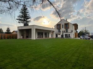 ein Haus mit großem Rasen davor in der Unterkunft Vis de Apuseni in Bălceşti