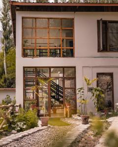una casa con grandes ventanas y plantas en el patio en Offto Resort Hunza, en Hunza