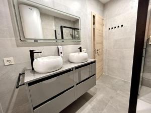 a bathroom with two sinks and a mirror at LUJO: 10 pax Proyector, Maquina Arcade y Patinetes in Oviedo