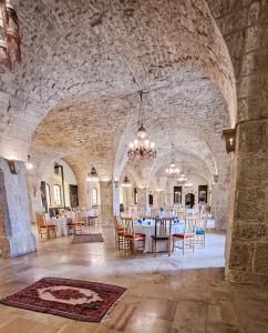 ein Esszimmer mit Tischen und Stühlen in einem Steingebäude in der Unterkunft Mir Amin Palace in Beit ed-Din