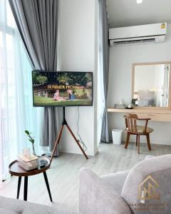 ein Wohnzimmer mit einem Flachbild-TV an der Wand in der Unterkunft นครพนม นอร์ดิกเฮ้าส์ in Nakhon Phanom