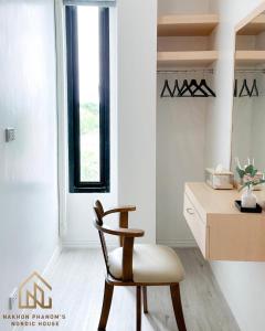 einen Stuhl in einem Zimmer mit einem Schreibtisch und einem Fenster in der Unterkunft นครพนม นอร์ดิกเฮ้าส์ in Nakhon Phanom