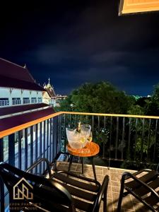 una mesa con 2 copas de vino en el balcón en นครพนม นอร์ดิกเฮ้าส์ en Nakhon Phanom