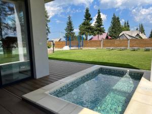 a swimming pool on a deck next to a yard at Vis de Apuseni in Bălceşti