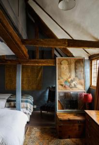 una camera da letto con un letto e un dipinto sul muro di Clarendon Cottage a Enfield