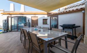 un patio con mesa, sillas y piano en La Casa de Felisin en Pulgar