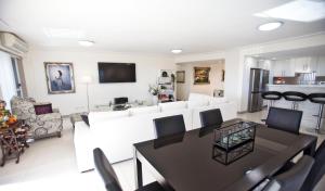安特兰斯Waterview luxury hideaway, 2 min walk to all, pool的客厅配有桌子和白色家具