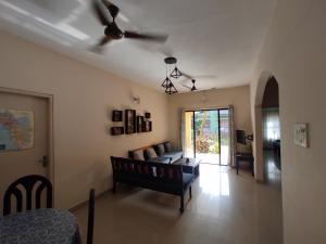 a living room with a couch and a ceiling fan at Beach Apartment 2,COLVA , GOA, INDIA in Colva