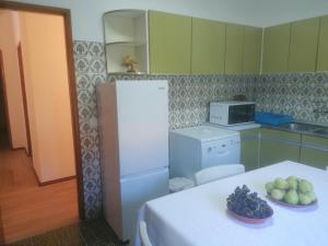 a kitchen with a white refrigerator and a table with fruit on it at River City House 