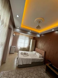 um quarto com uma cama grande e um tecto amarelo em Mardin Expert Otel em Mardin