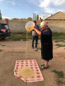 Eine Frau schüttet Essen in eine Glasschüssel in der Unterkunft Song Kol Flex Travel guests house in Dzhangyaryk