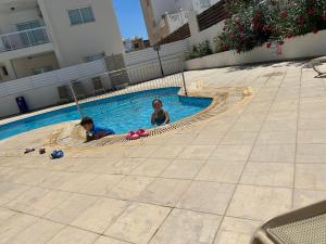 two children playing in a swimming pool at Sidra's Apartment in Paralimni