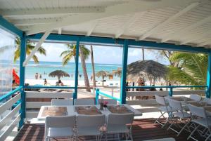 a restaurant with a table and chairs on the beach at Villa Créole Domaine privé de l'Anse des Rochers in Saint-François