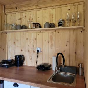 una cucina con lavandino e bancone con pareti in legno di Zagroda Zabłocie 