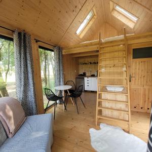 Zimmer mit einem Bett und einem Tisch in einer Hütte in der Unterkunft Zagroda Zabłocie 