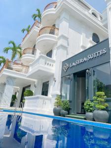 a white building with a swimming pool in front of it at La Sera Suites Nha Trang in Nha Trang