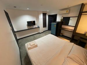a bedroom with a bed and a tv in a room at Islanda Hotel Patong in Patong Beach