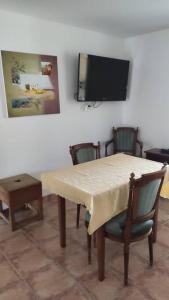 Un comedor con mesa y sillas y un televisor. en La Casetta T2 RDC avec jardin à Ruoms, en Ruoms