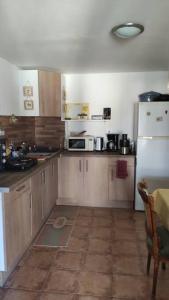 Una cocina con gabinetes de madera y un refrigerador blanco. en La Casetta T2 RDC avec jardin à Ruoms, en Ruoms