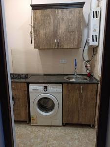 a small kitchen with a washing machine and a sink at Arev guesthouse Goris in Goris