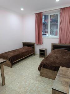 a hotel room with two beds and a window at Arev guesthouse Goris in Goris