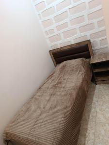 a bed in a room with a brick wall at Arev guesthouse Goris in Goris