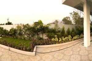 a retaining wall with flowers and a fence at Willow the Villa in Hyderabad