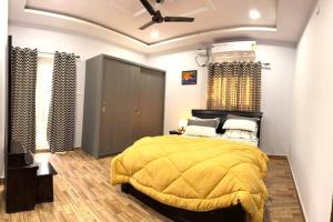 a bedroom with a yellow bed and a ceiling at Willow the Villa in Hyderabad