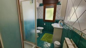 y baño con 2 aseos, lavamanos y ducha. en Villa Daniela, en Sarno