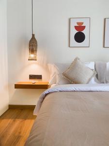 a bedroom with a bed and a table with a clock on it at Reset Lombok Hotel in Kuta Lombok