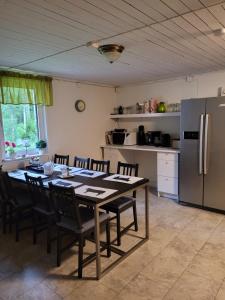 a kitchen with a table with chairs and a refrigerator at Karlstorp 4 km från Vimmerby in Vimmerby