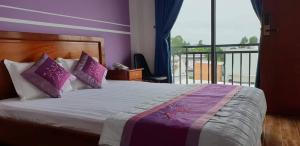 ein Schlafzimmer mit einem großen Bett und einem Balkon in der Unterkunft LẠI NGUYỄN BOUTIQUE HOTEL in Cần Thơ