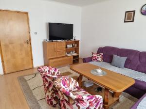 a living room with a purple couch and a table at House Osjek Ilidza in Ilidža