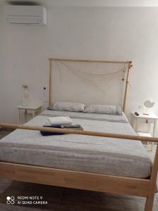1 cama con marco de madera en un dormitorio en Casa vacanze Tre stelle, en Termoli