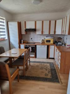 House Osjek Ilidza في إيليجا: مطبخ مع طاولة خشبية وغرفة طعام