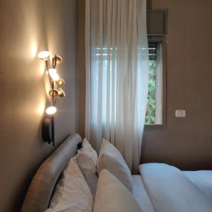 a bedroom with a bed with two pillows and a window at Urbanica Carmel- Apartments in Haifa