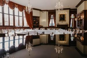 a large room with white tables and chandeliers at The Orwell Hotel in Felixstowe
