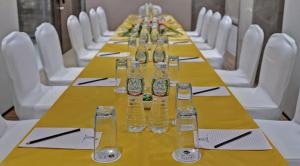 a long table with glasses on it with white chairs at Hotel Suba Star Ahmedabad in Ahmedabad +19 photos