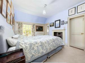 a bedroom with a bed and a fireplace at Clarendon Cottage in Enfield