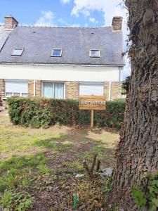 een bord voor een huis met een welkomstgeschenk bij Landon Cottage in Campénéac