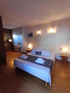 a bedroom with a large bed with two towels on it at Le Clos du Bois Joli in Lagnieu